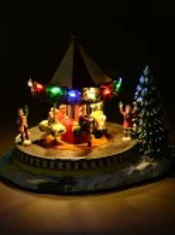 New Christmas Warehouse Kids Enjoying A Winter Fun Park Merry-Go-Round Christmas Village Scene - 23Cm